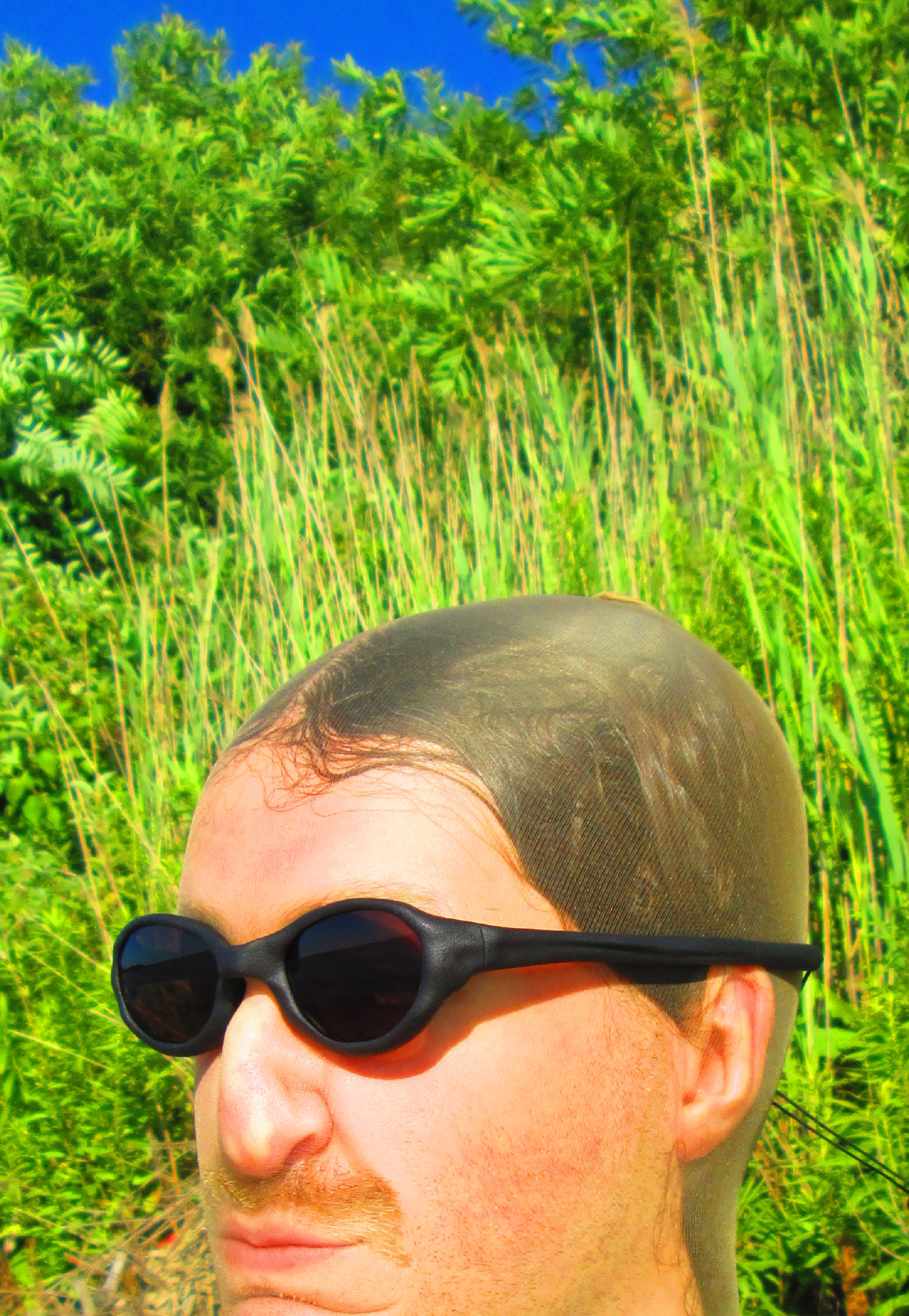 3D render of a bald model wearing black sunglasses with transparent grey lenses